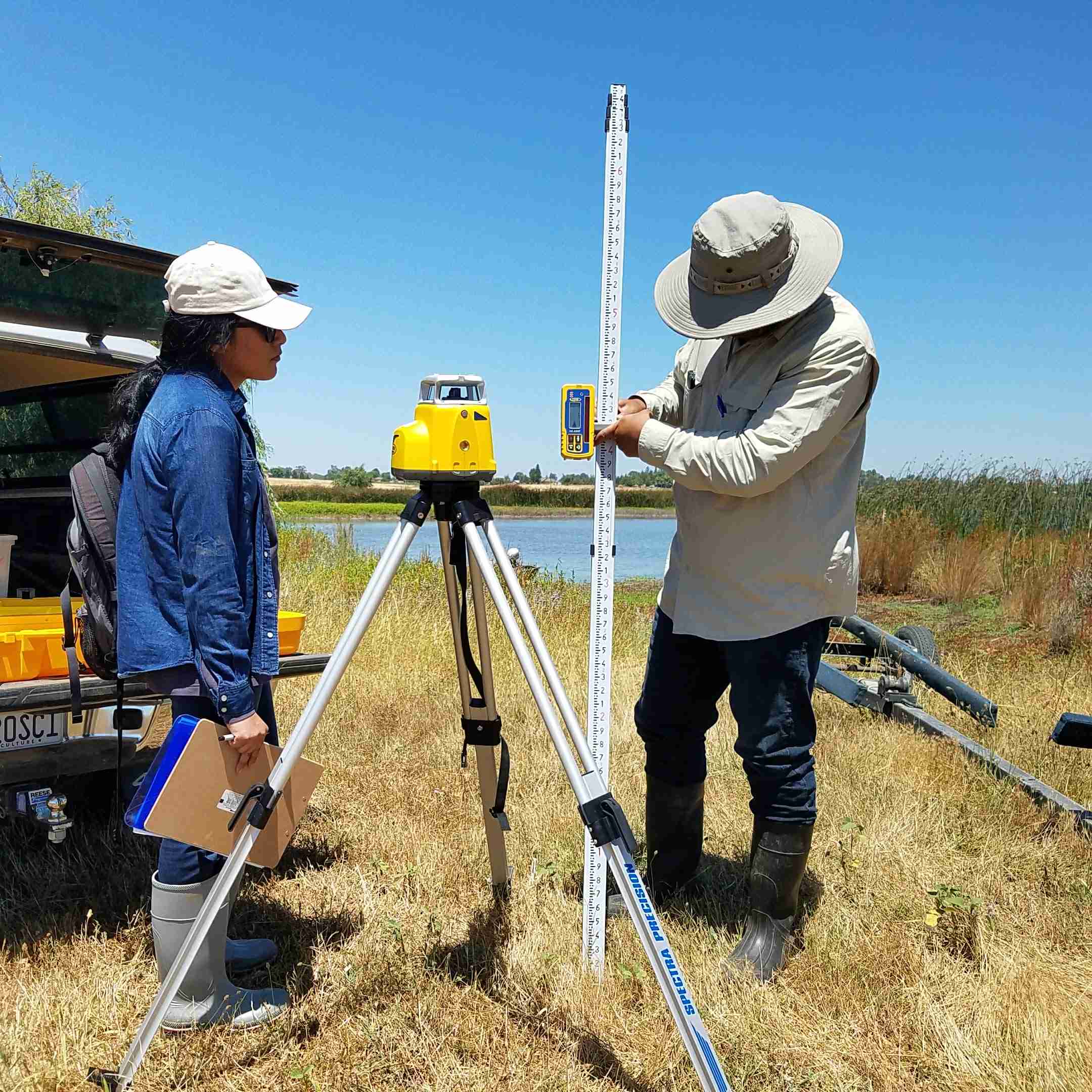 Blankinship and Associates staff setting up surveying equipment to caculate maximum irrigation pond storage volume.